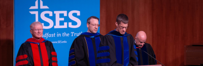 SES Faculty, Dr. Richard G Howe, Dr. Mel Winstead, and Dr. J Thomas Bridges with President Phil Ginn praying at SES graduation